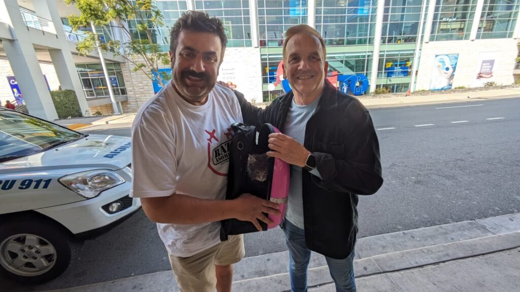 Two men smiling with a black Maine Coon kitten after our trusted pet courier delivered it to its new home in Quito, Ecuador