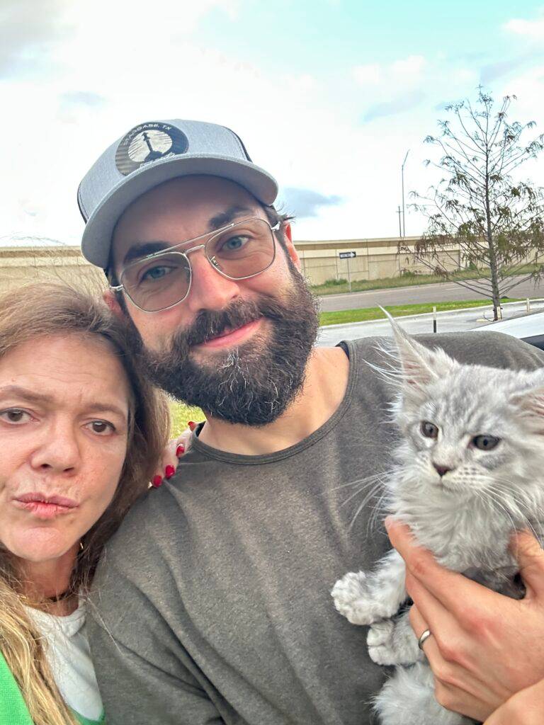Selfie of a new owner smiling with his silver Maine Coon kitten at a midpoint meetup in Kingsville, Texas